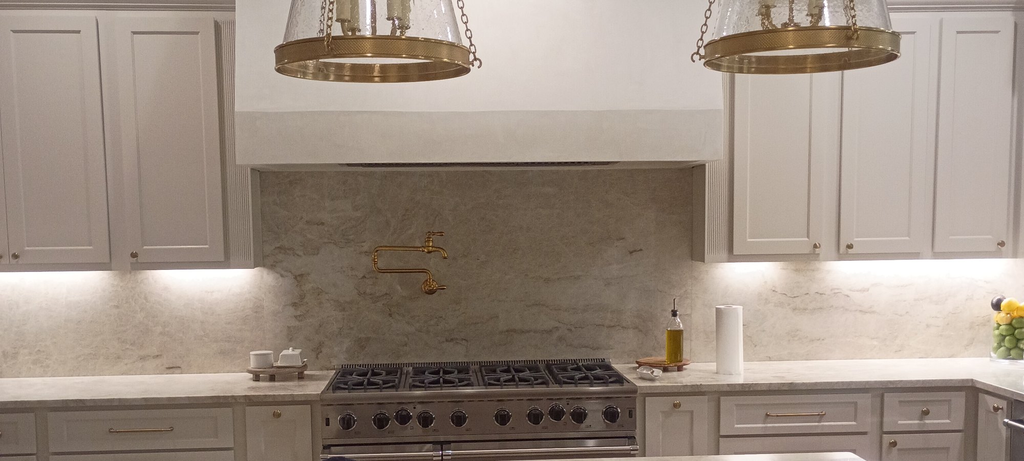 Refinished cabinetry around the range with plaster hood and pendants