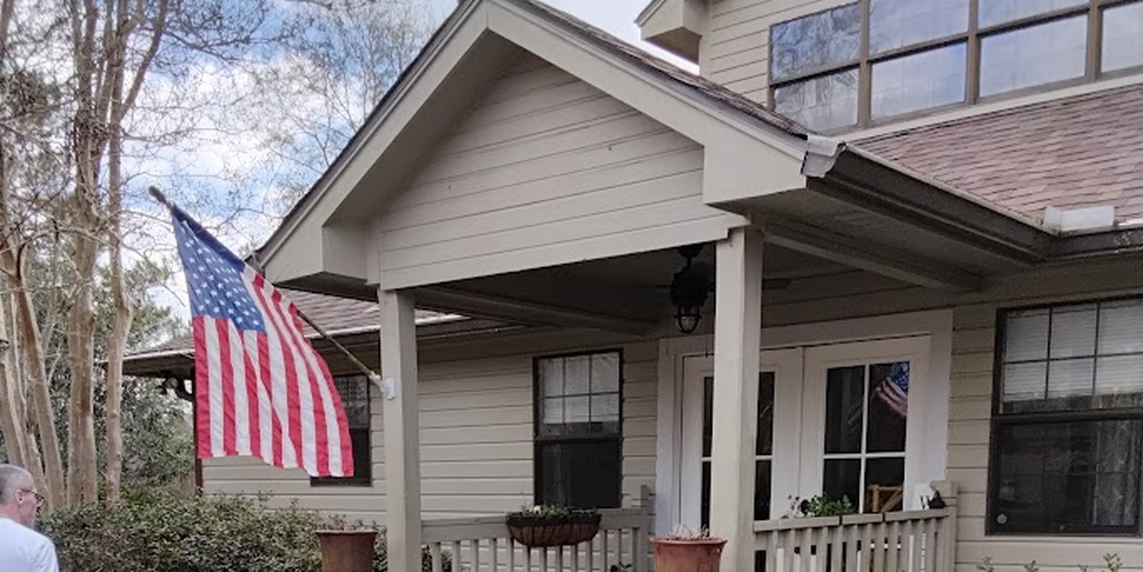 The home before painting, tan siding with white trim