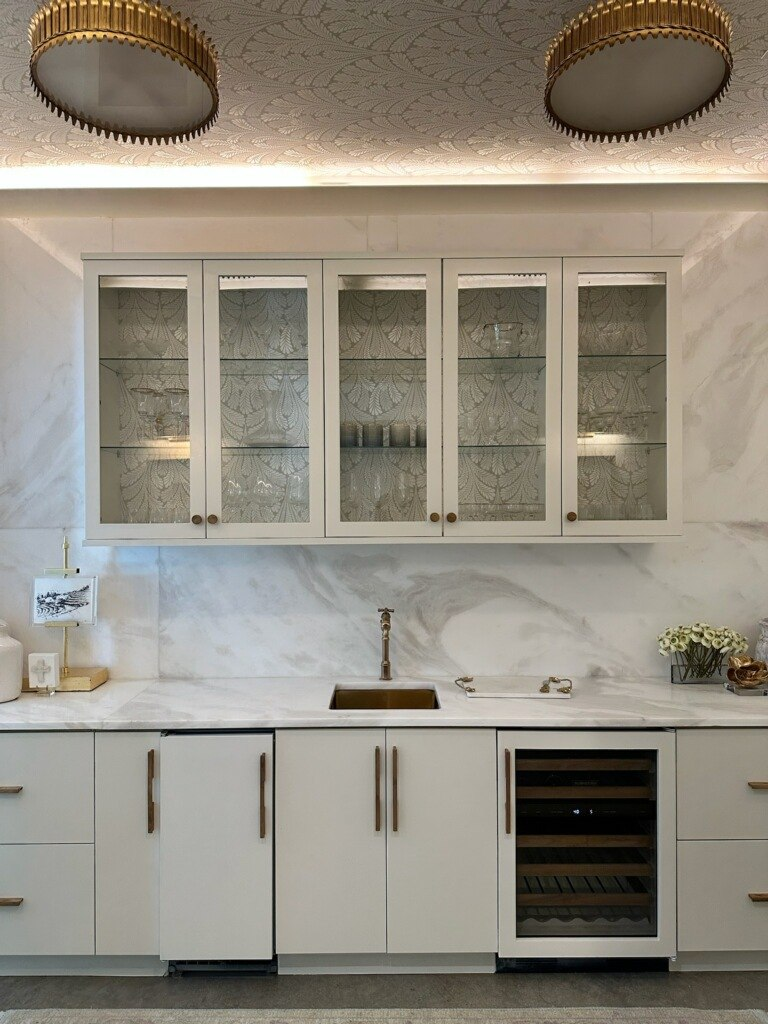 Painted white kitchen cabinets with marble backsplash
