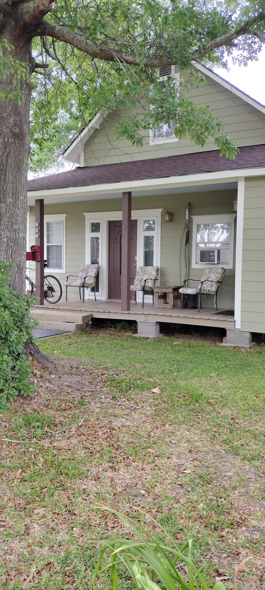 Freshly painted sage green home exterior with front porch